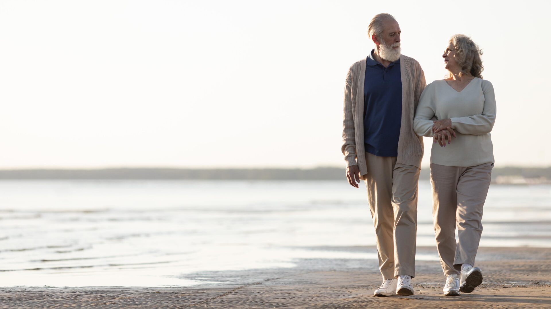 Couple enjoying a peaceful walk on the beach at sunset