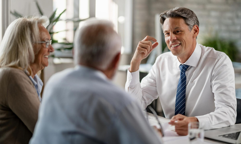 Financial advisor meeting with an older couple, explaining how to shift asset allocation by age toward retirement