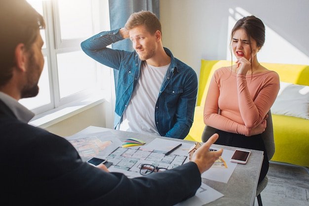 Young couple looking confused and stressed with an advisor over documents, illustrating the estate planning mistakes retirees should avoid