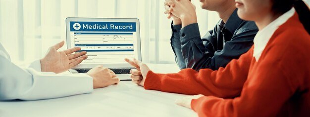 Doctor and two people reviewing medical records on a laptop, comparing Medicare plans side by side