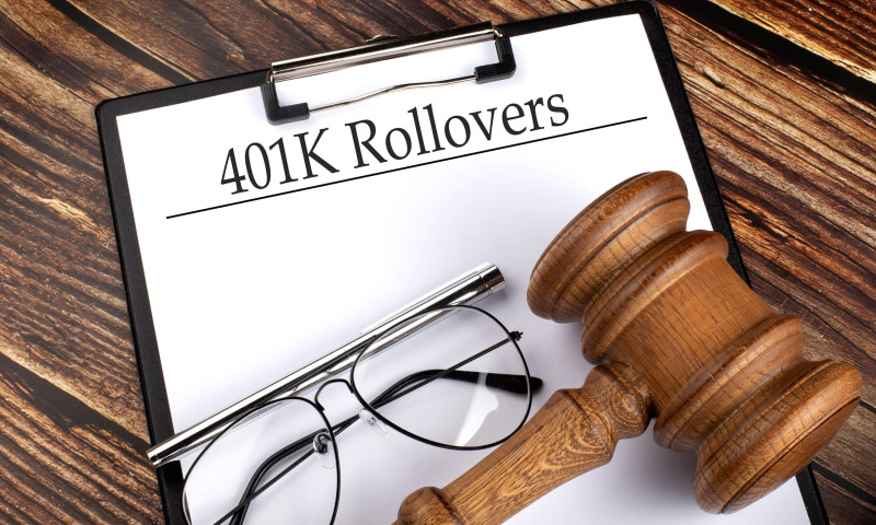 Clipboard labeled 401K Rollovers with reading glasses and a gavel, introducing the complete guide to 401(k) rollovers