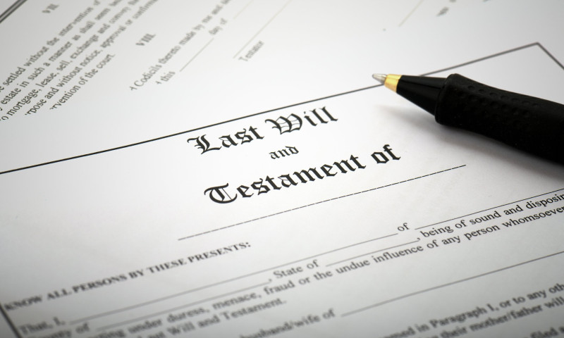 Last Will and Testament document with a black pen resting on top, ready to be signed to ensure the will covers all assets