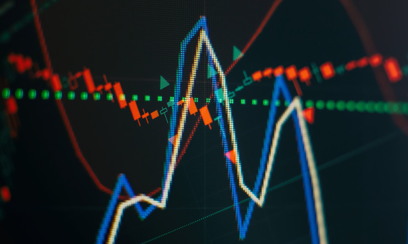 Volatile candlestick chart on a trading screen, showing the market swings retirees must navigate when investing