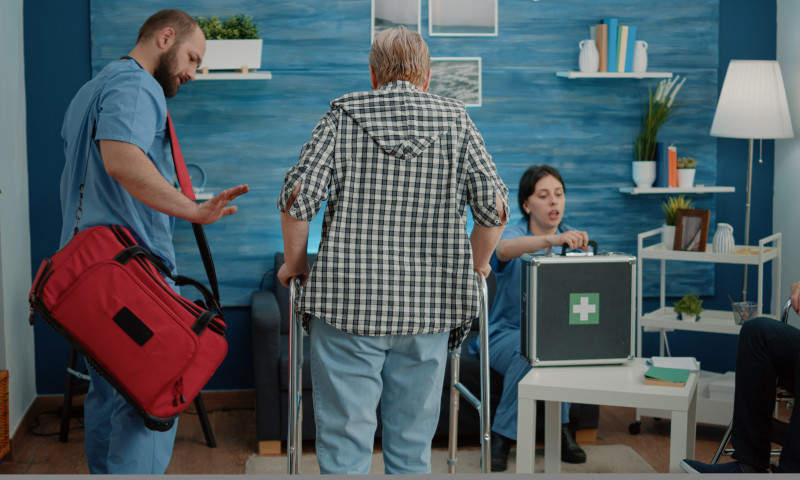Healthcare workers helping an elderly patient with a walker, navigating how to move states without losing healthcare