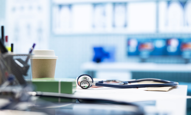 Stethoscope on a desk in a blurred medical office, representing the pros and cons of Medicare Advantage plans