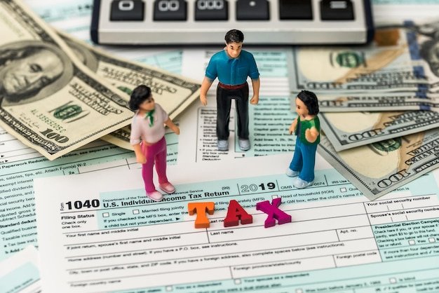 Miniature figures on a 1040 tax form with a calculator, weighing the pros and cons of converting to a Roth IRA