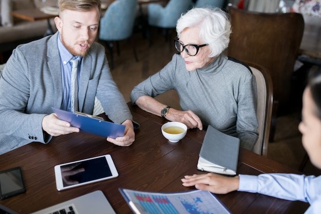 Advisor showing bond and portfolio documents to an older woman, explaining the role of bonds in retirement