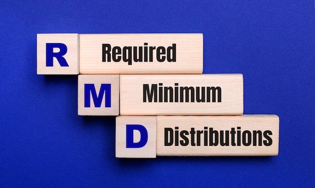 Wooden letter blocks spelling RMD Required Minimum Distributions, explaining the mandatory withdrawals retirees must take each year