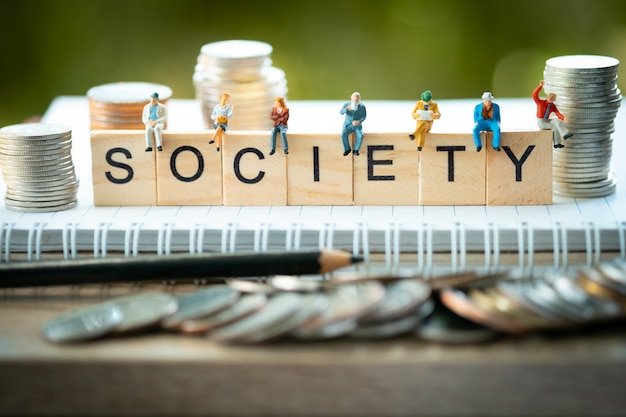Miniature figurines on wooden blocks spelling SOCIETY with stacked coins illustrating the 35-year earnings rule