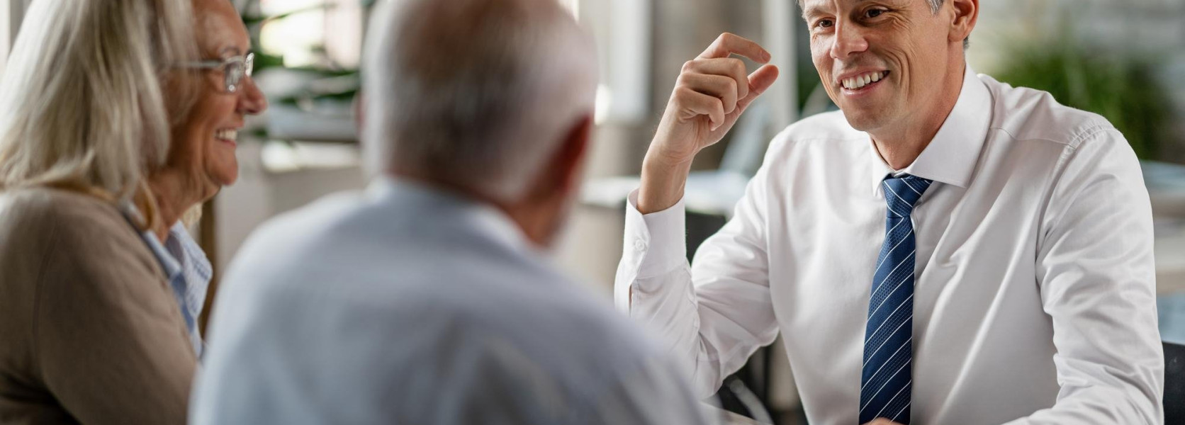 Financial advisor meeting with an older couple, explaining how to shift asset allocation by age toward retirement