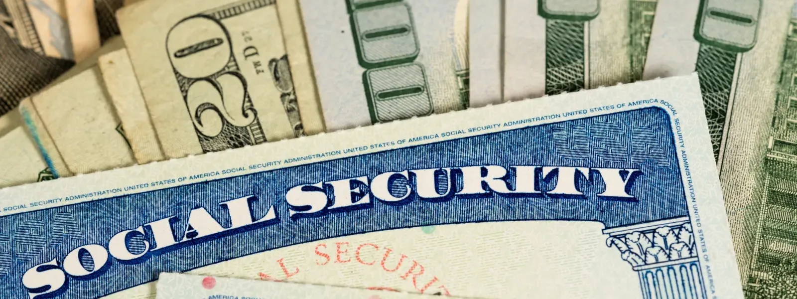 Two Social Security cards fanned over dollar bills, illustrating what the average Social Security payment looks like in 2025