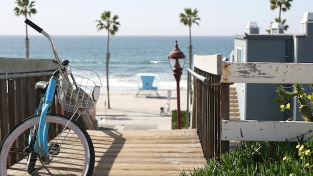 Blue bicycle on a sunny boardwalk with palm trees, evoking the best beach towns to retire in the US