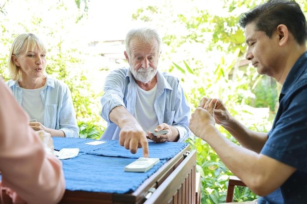 Group of retirees playing cards outdoors, representing the active lifestyle that charitable giving strategies can support in retirement