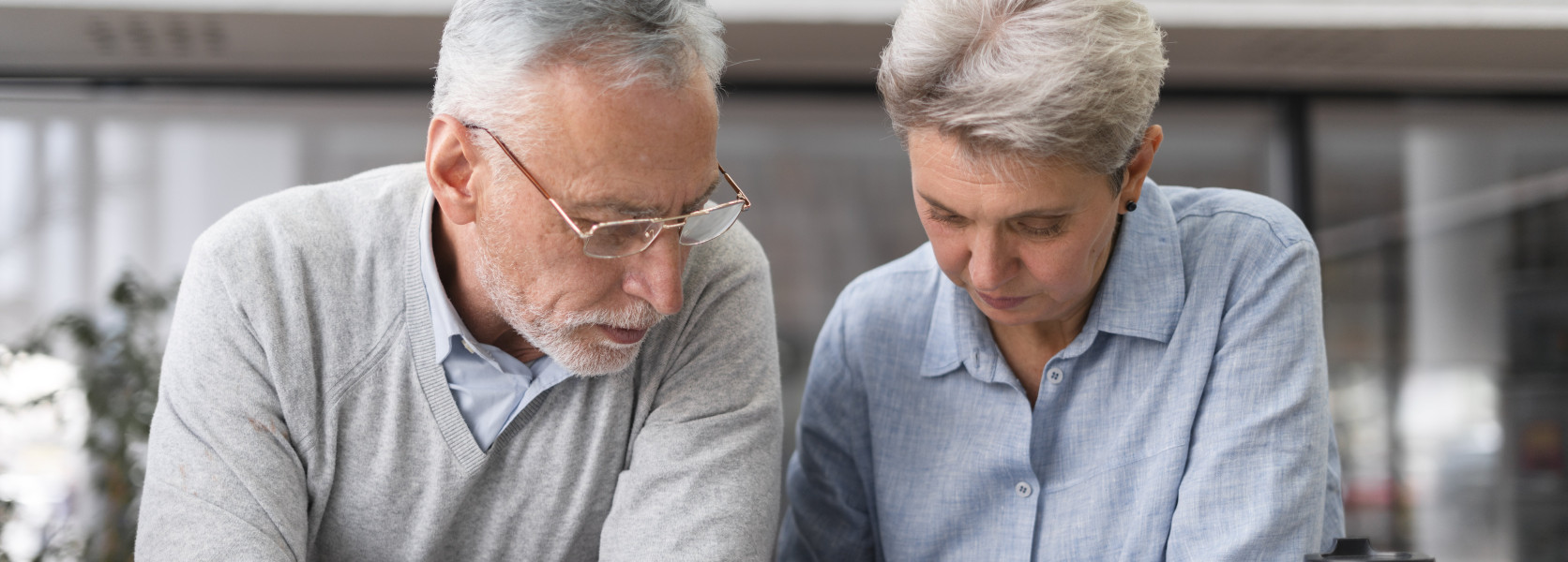 Older couple seated together writing in a notebook, carefully mapping out a Coast FIRE plan and letting compounding do the rest