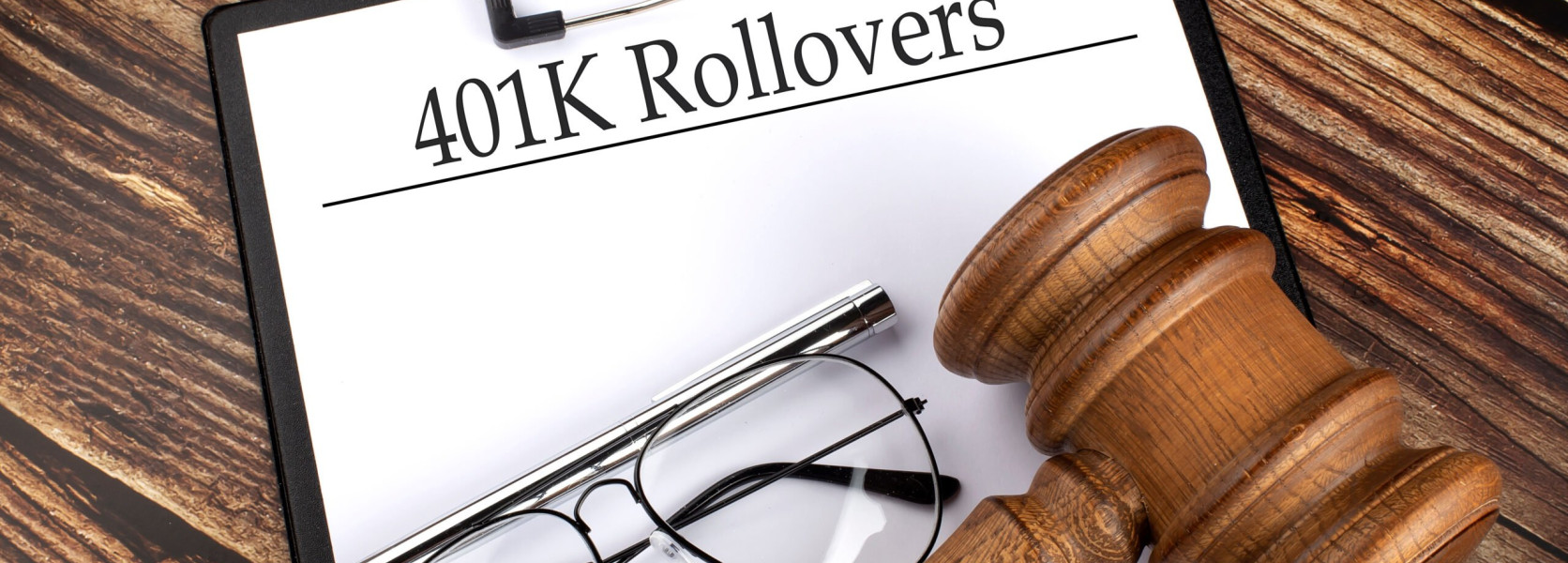Clipboard labeled 401K Rollovers with reading glasses and a gavel, introducing the complete guide to 401(k) rollovers