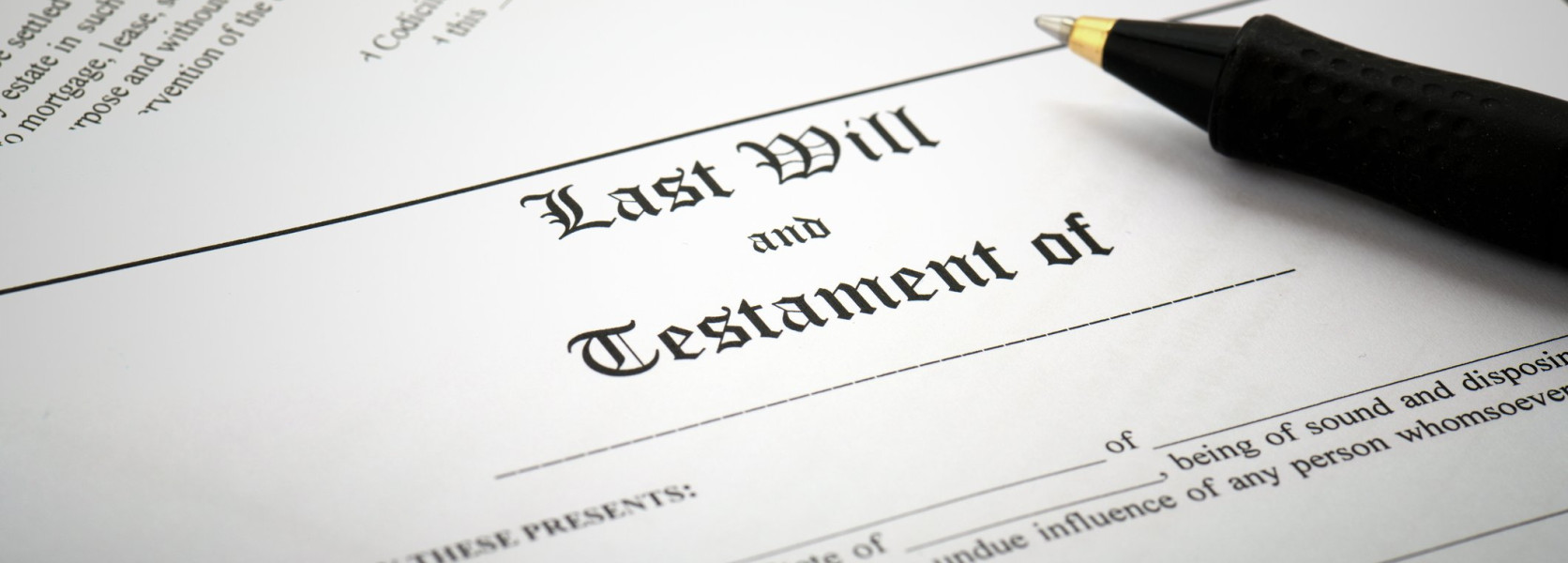 Last Will and Testament document with a black pen resting on top, ready to be signed to ensure the will covers all assets