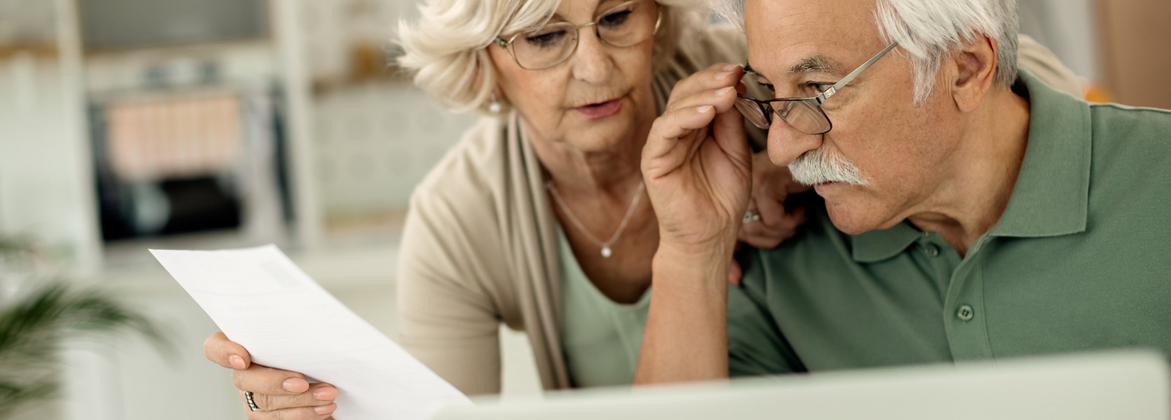 Older couple reviewing a financial document together, checking if their target-date fund aligns with retirement goals