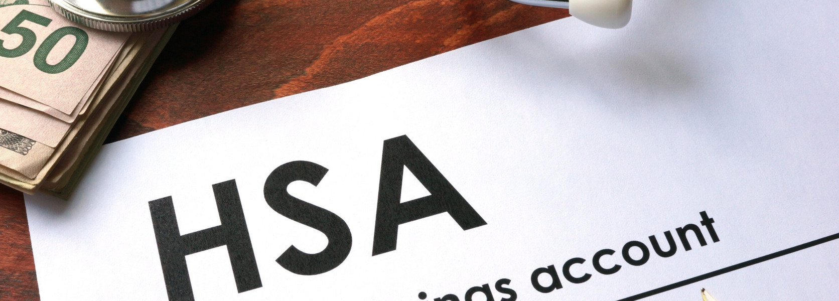 HSA document beside a stethoscope and cash, showing how a health savings account supports retirement healthcare funding