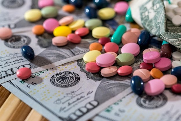 Colorful prescription pills scattered over US dollar bills, showing ways to lower prescription drug costs