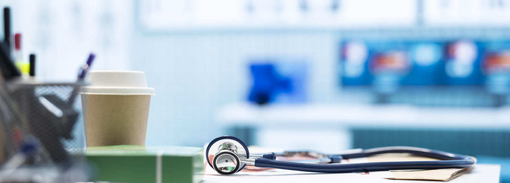 Stethoscope on a desk in a blurred medical office, representing the pros and cons of Medicare Advantage plans