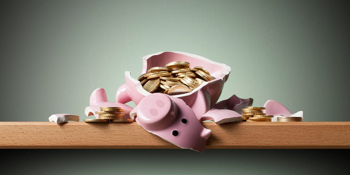 Broken pink piggy bank spilling gold coins, illustrating how to access retirement savings before 59 without triggering early withdrawal penalties